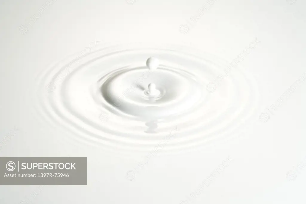 A drop falling onto surface of milk