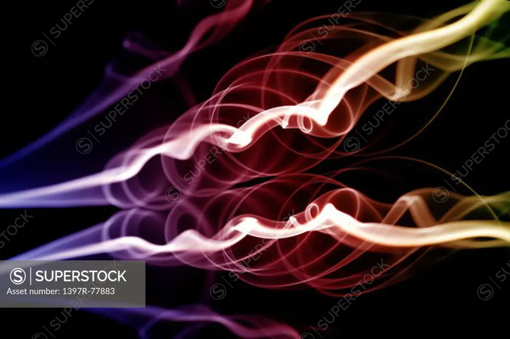 Ethereal drift of smoke swirling with a rainbow effect coloration on black background