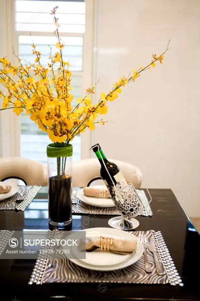 Dining table with vase flower and red wine