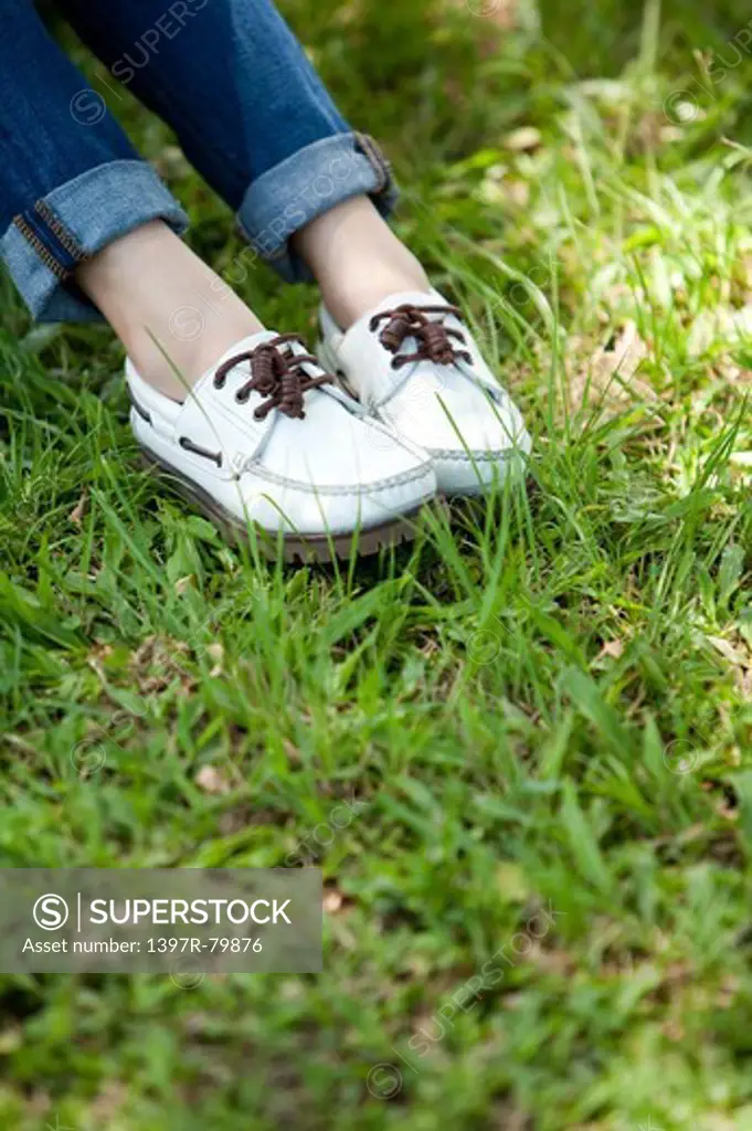 Close-up of young woman's shoes on the lawn