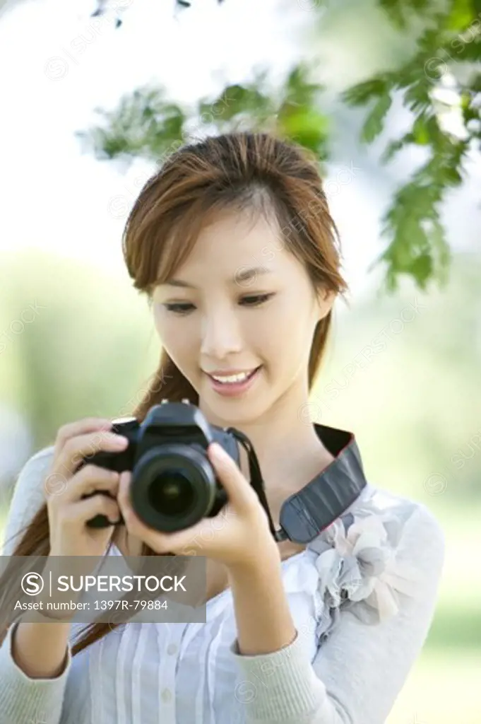 Young woman holding camera with smile