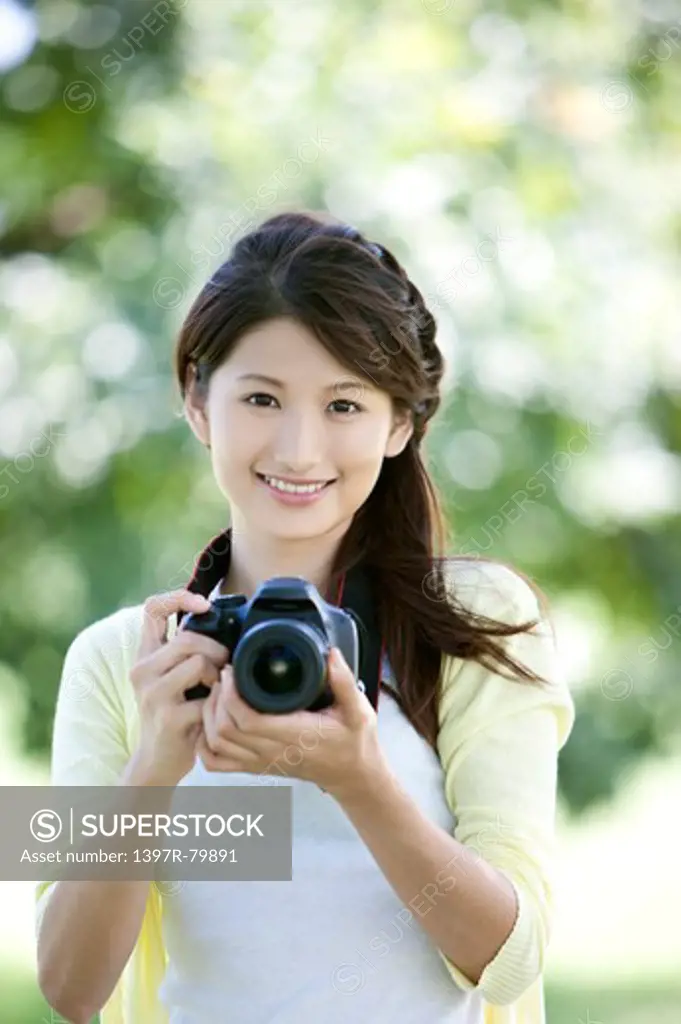 Young woman holding camera with smile