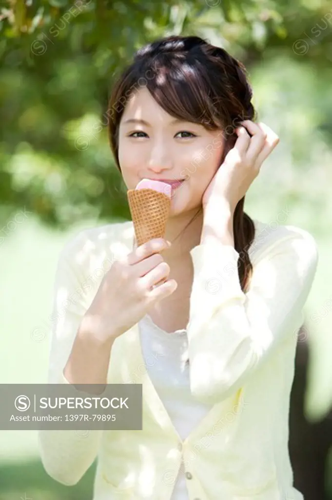 Young woman eating an ice cream and smiling