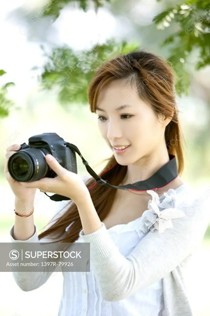 Young woman holding camera and smiling