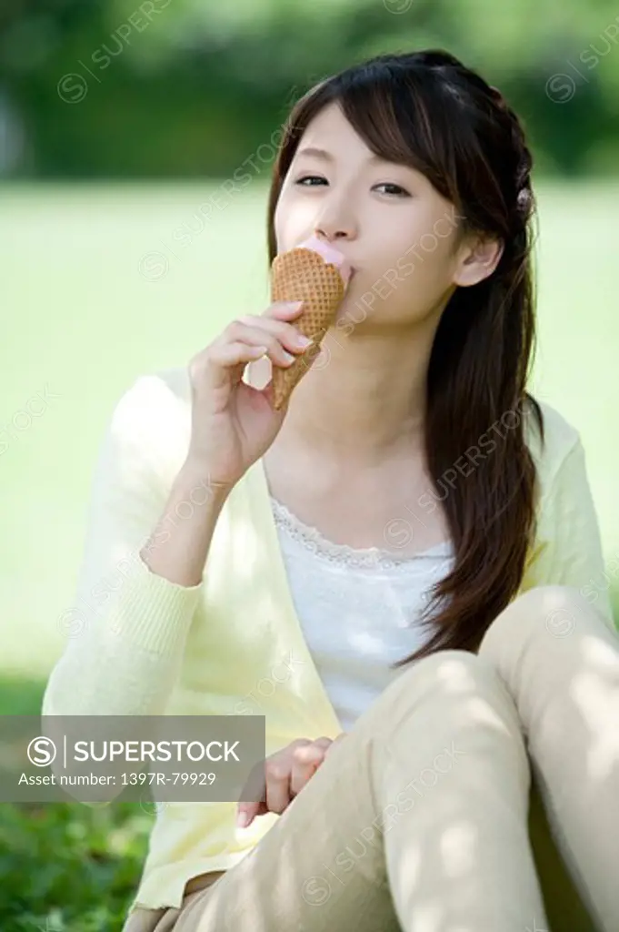 Young woman sitting and eating ice cream