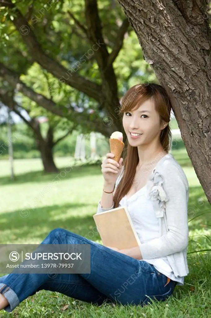 Young woman holding an ice cream and smiling at the camera