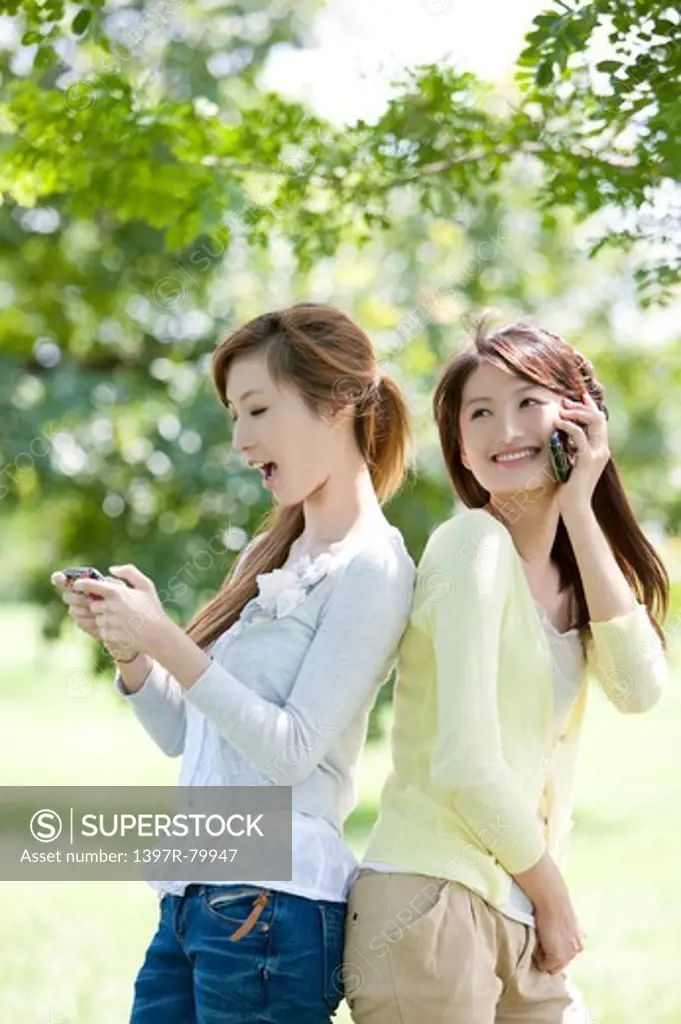 Young women holding mobile phone with smile