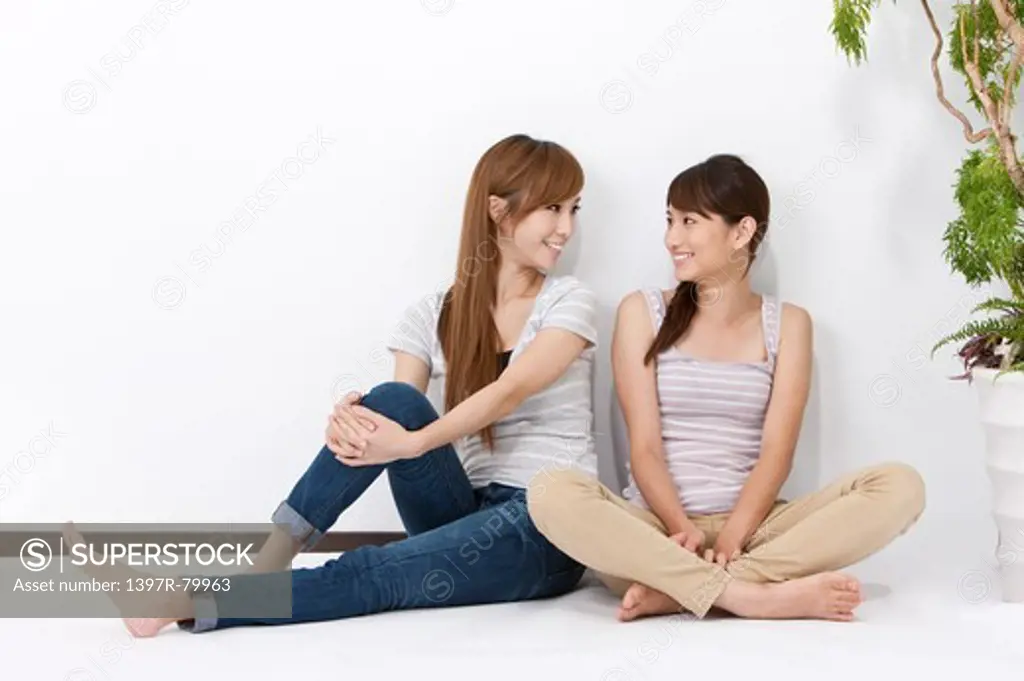 Young women sitting on the floor and smiling