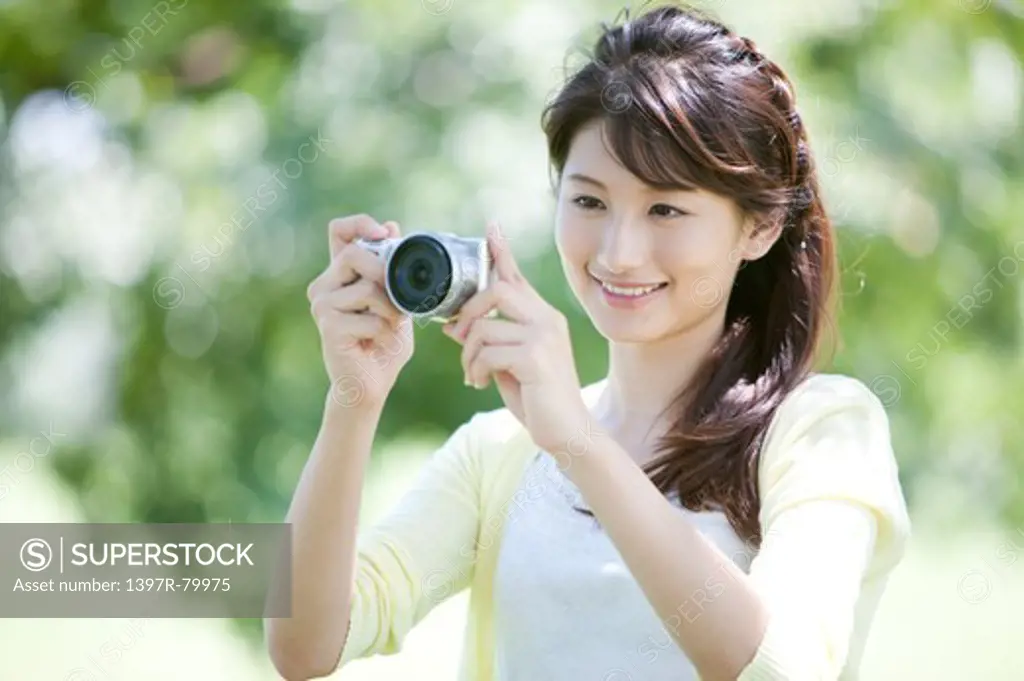 Young woman photographing and smiling