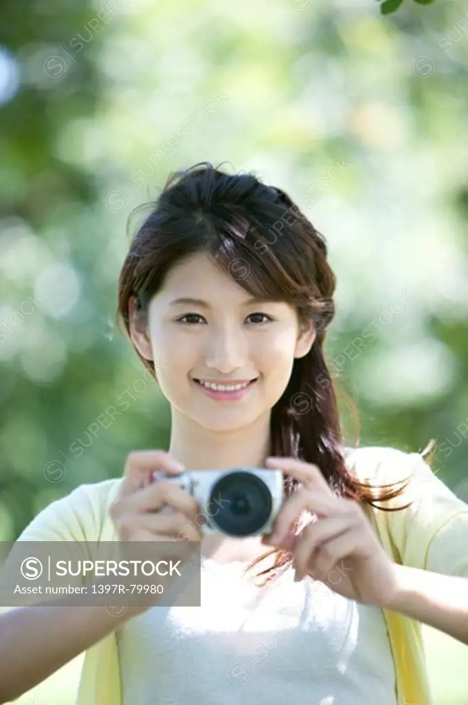 Young woman photographing and smiling at the camera