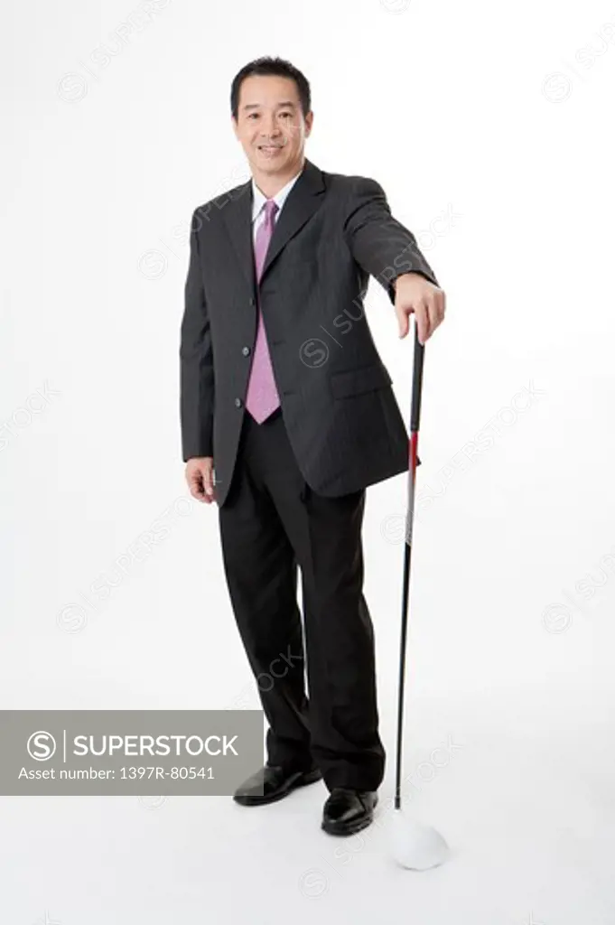 Business man holding golf swing and smiling at the camera