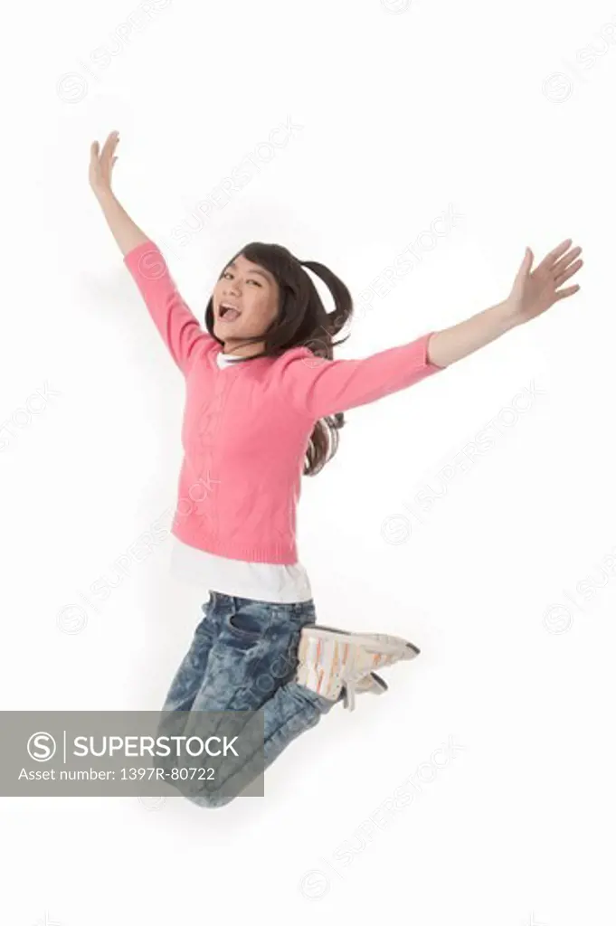 Young woman jumping in mid-air and laughing happily