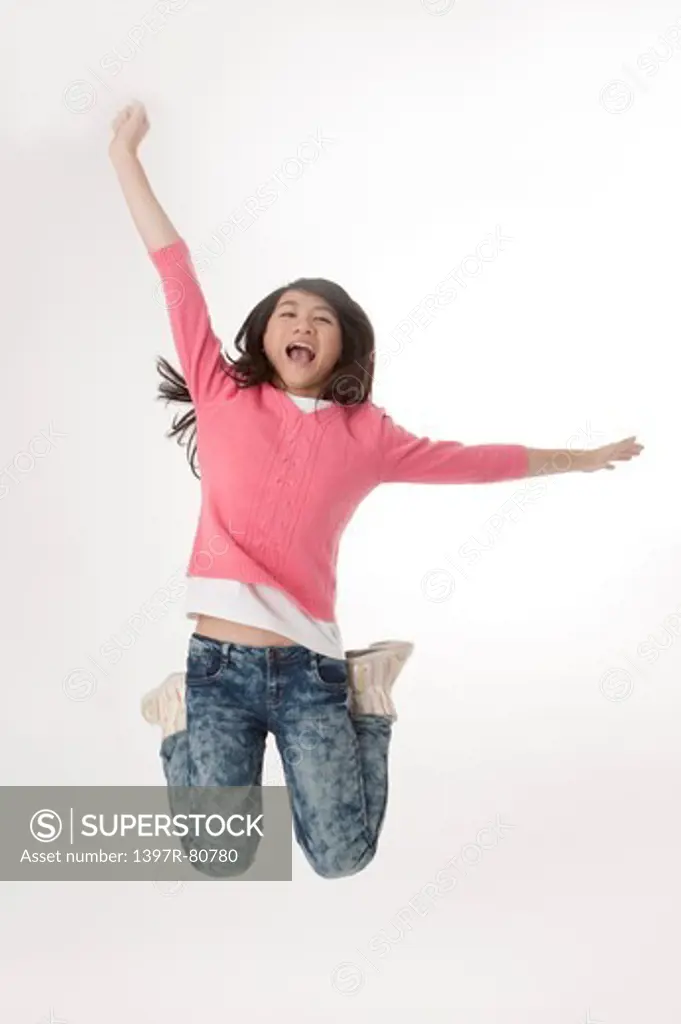Young woman jumping in mid-air and laughing happily