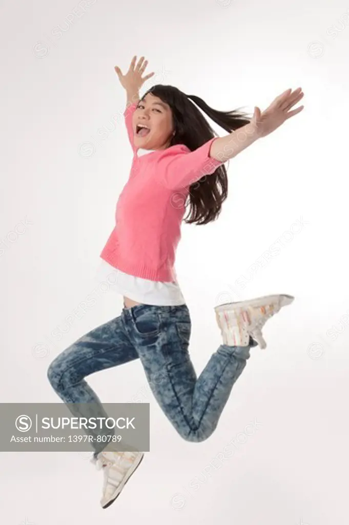 Young woman jumping in mid-air and smiling happily