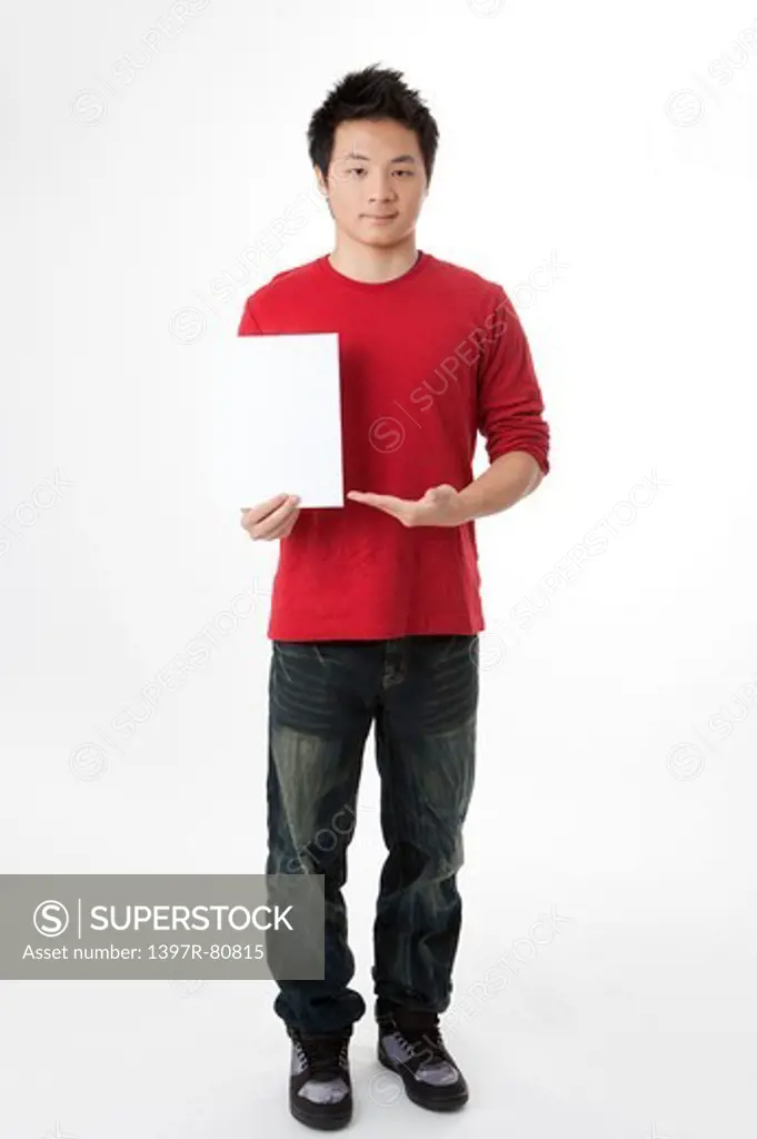 Teenage boy holding a paper and looking at the camera
