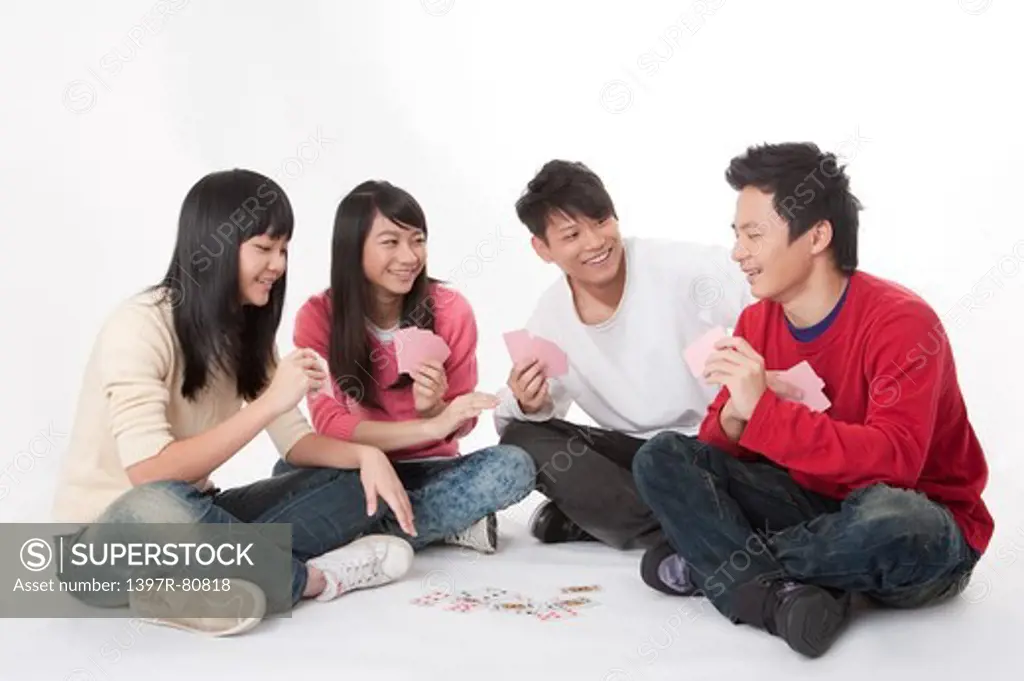 Teenagers and young adults sitting and playing poker