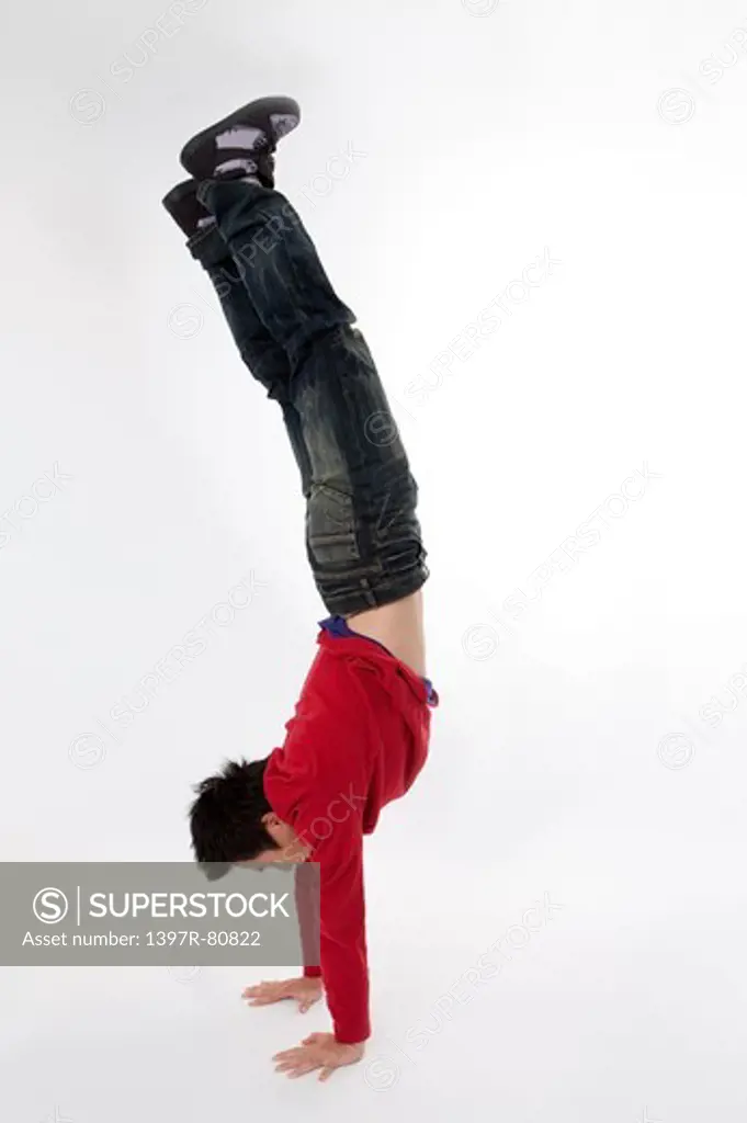 Teenage boy headstand and looking away