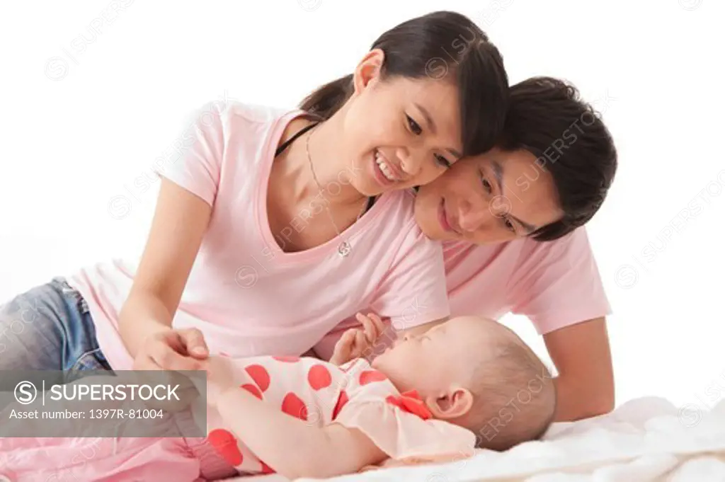 Young parents looking at baby girl with smile