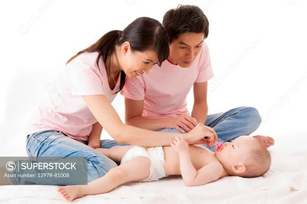 Young parents looking at the baby girl with smile
