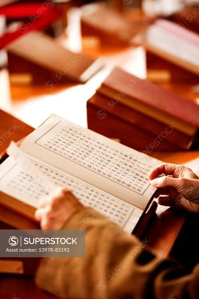 Human hands holding ancient book