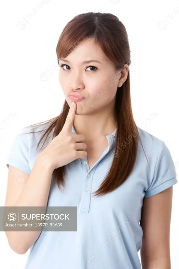 Young woman pouting, finger on chin