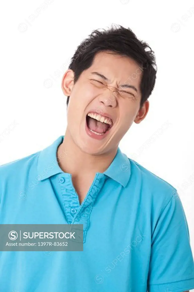 Young man shouting with mouth open widely
