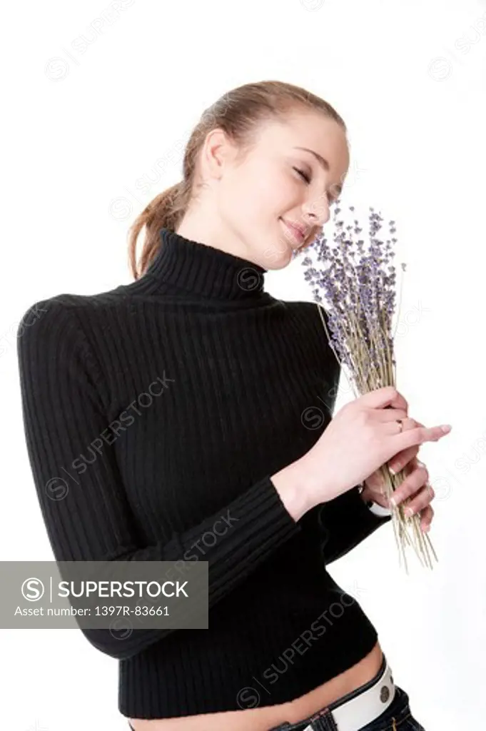Beautiful teenage girl smelling a bunch of flowers, smiling