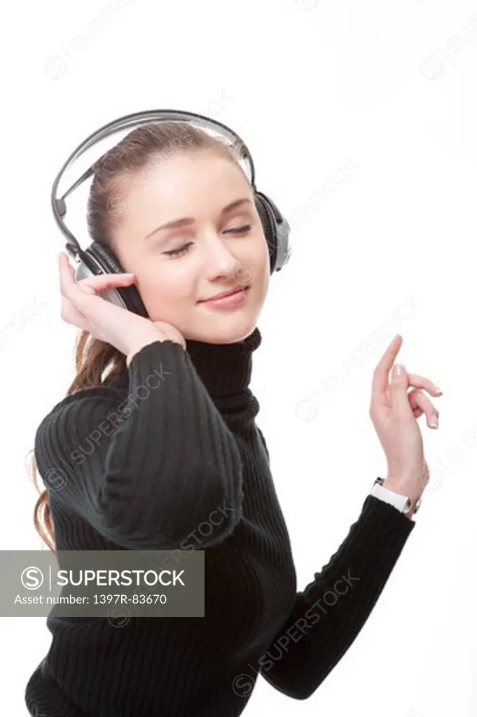 Beautiful teenage girl listening to music on headphones, eyes closed