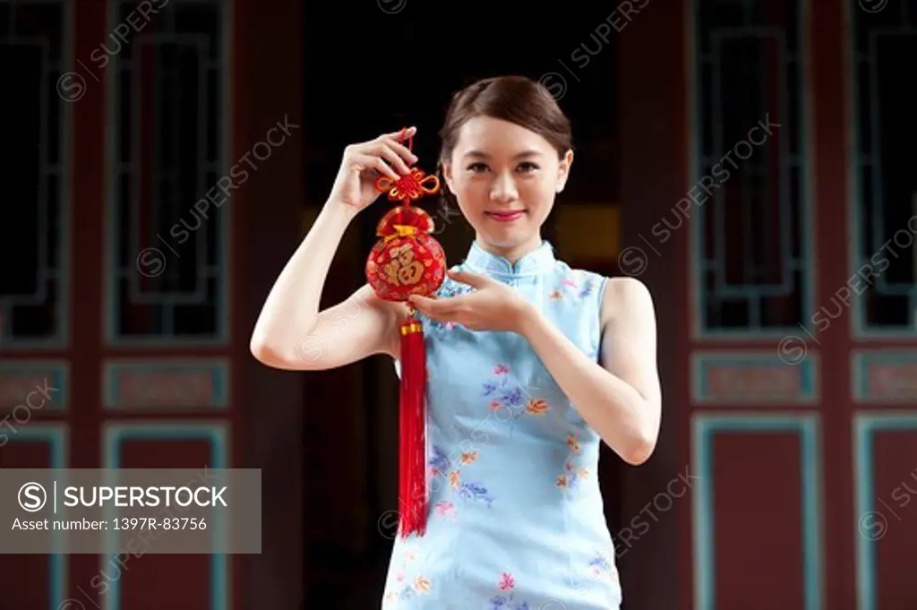 Young woman with cheongsam and holding decoration with smile