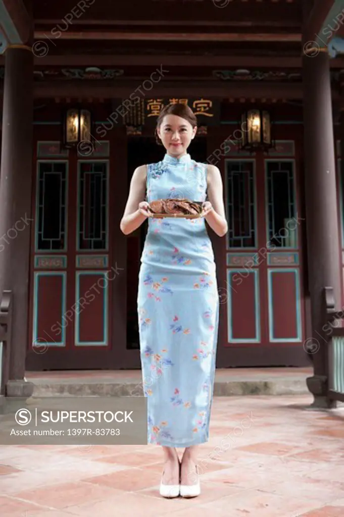 Young woman with cheongsam standing and smiling at the camera