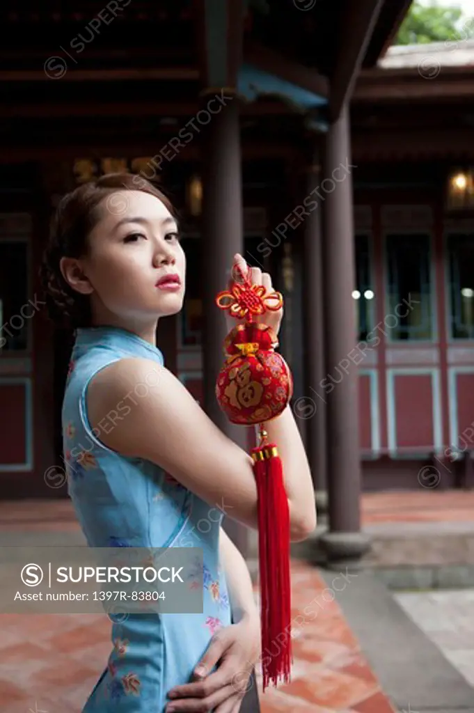 Young woman with cheongsam holding decoration