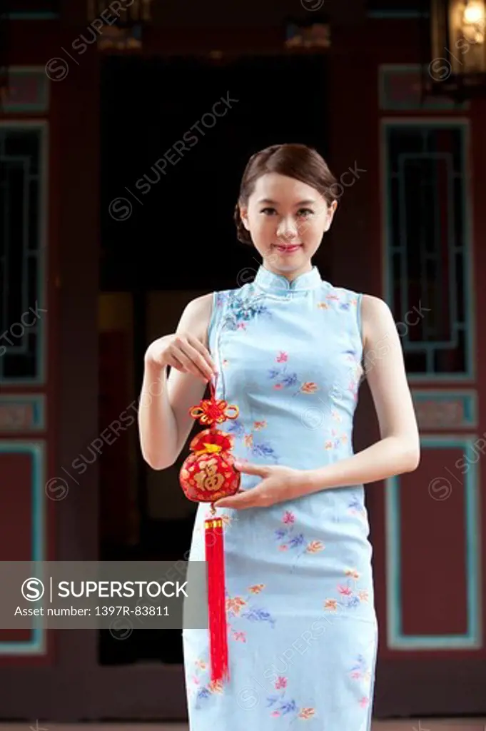 Young woman with cheongsam holding decoration with smile