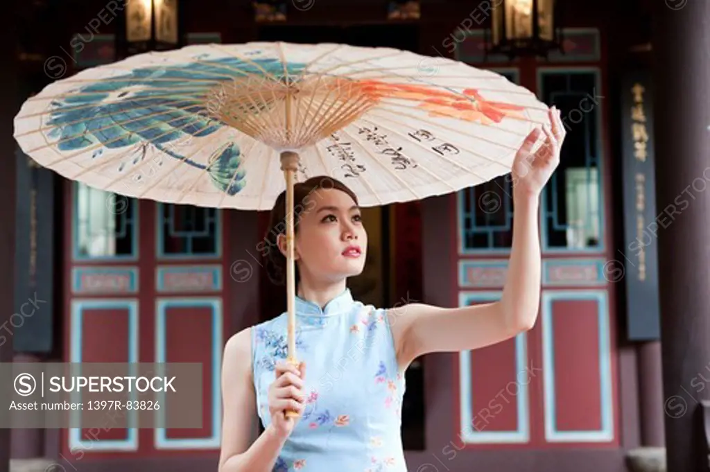 Young woman with cheongsam holding paper umbrella
