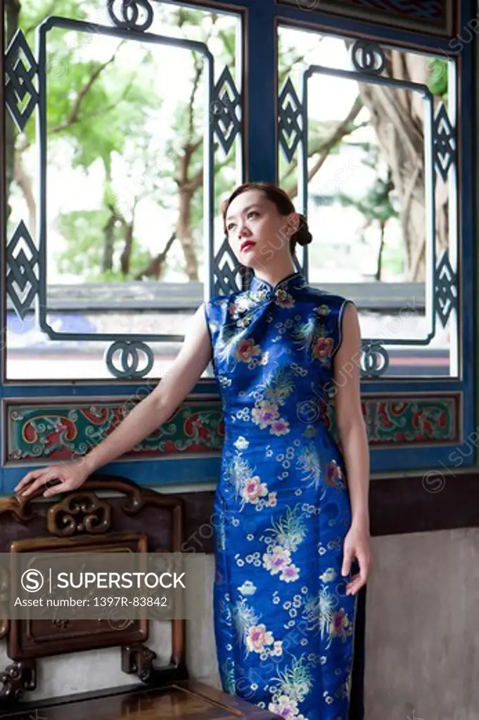 Young woman wearing cheongsam and looking up