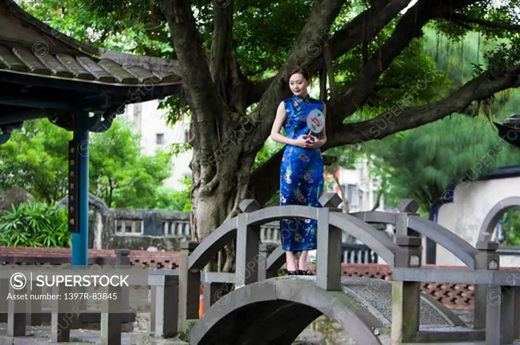 Young woman wearing cheongsam and standing