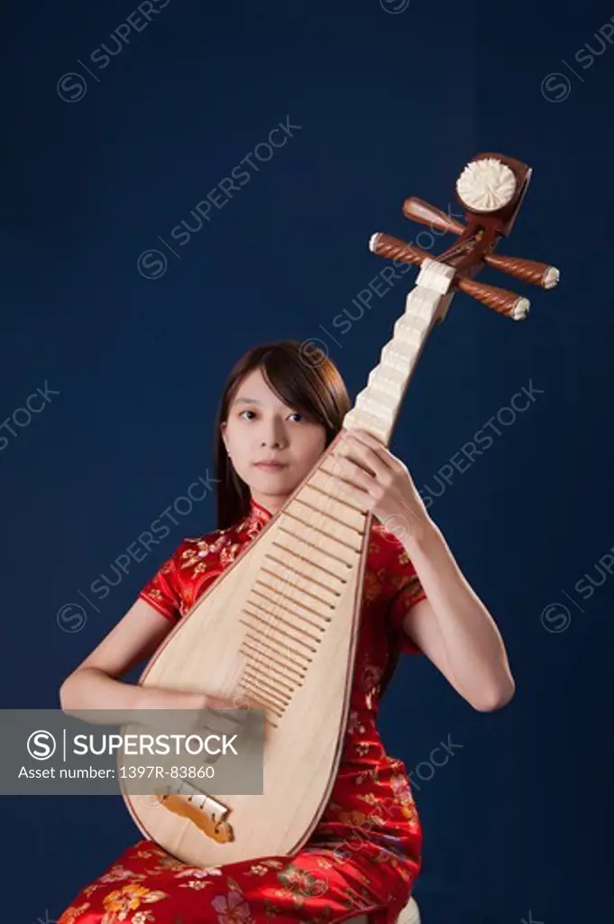 Young woman wearing cheongsam and playing pipa