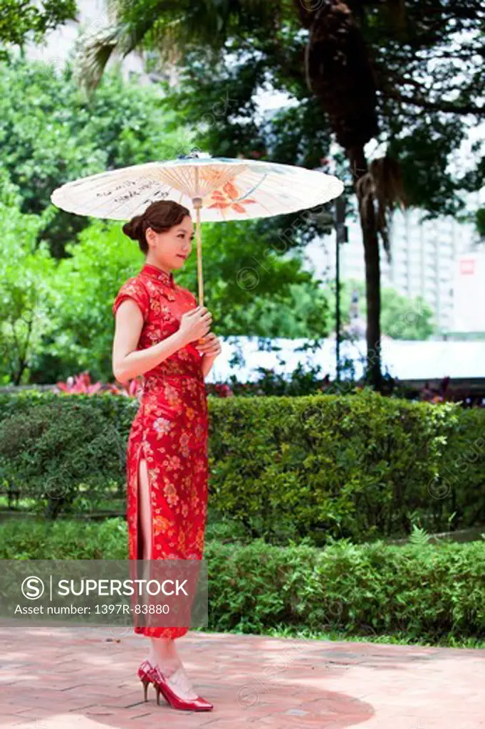 Young woman wearing cheongsam and holding paper umbrella