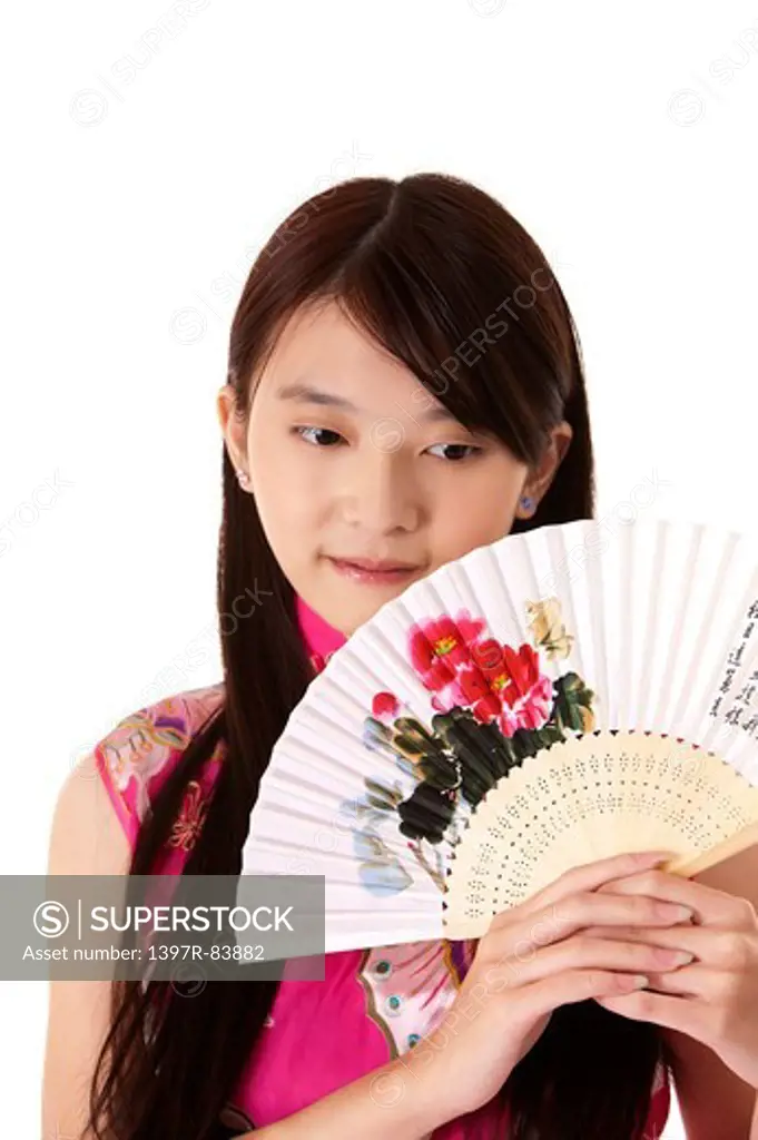 Young woman wearing cheongsam and holding folding fan