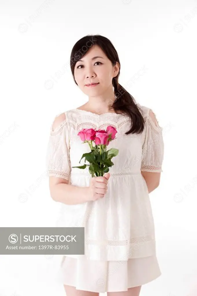 Mature woman holding a bunch of flowers and smiling at the camera