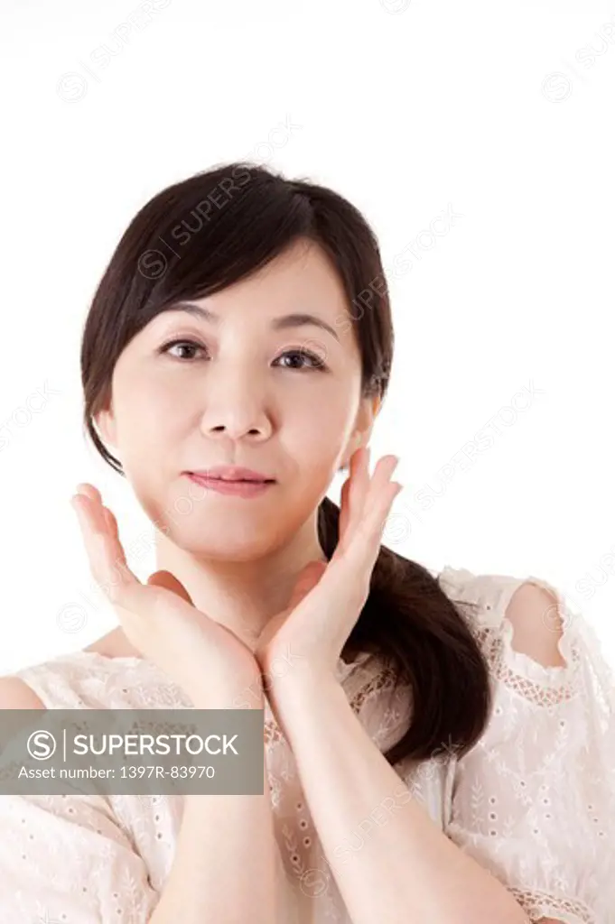 Mature woman smiling at the camera with hands on chin
