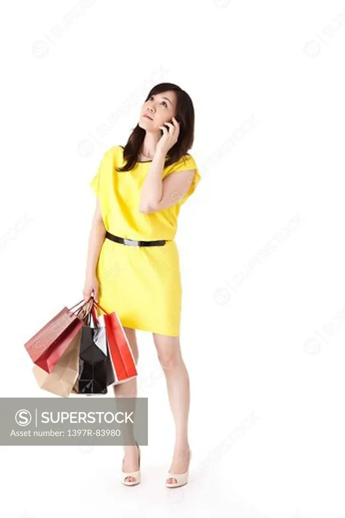 Mature woman holding shopping bags and on the phone