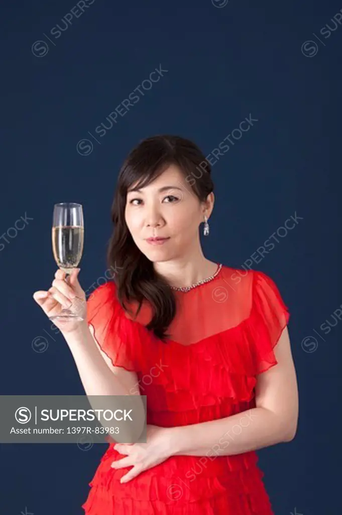 Mature woman holding wineglass and smiling at the camera