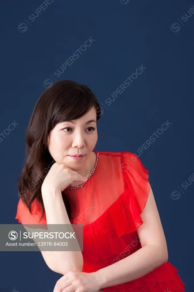 Mature woman looking away with head in hands