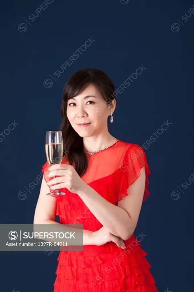 Mature woman holding wineglass and smiling at the camera