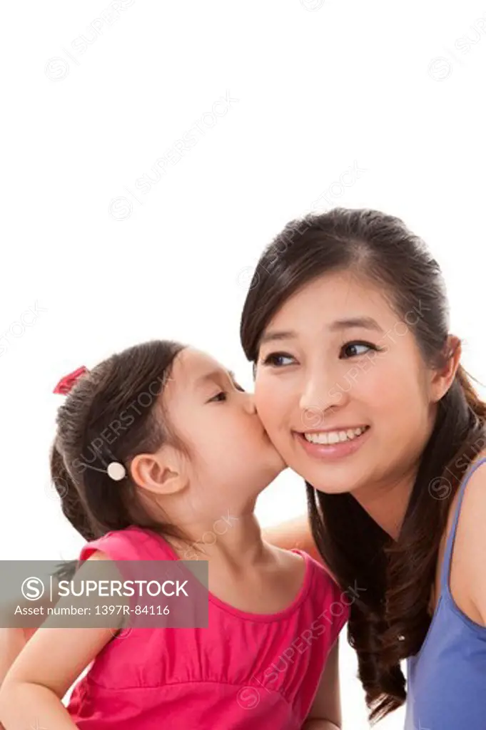 Daughter kissing mother and smiling