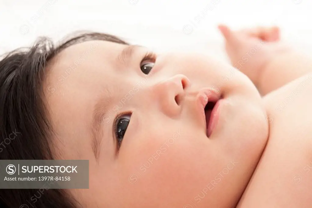 Close-up of a baby girl lying in bed