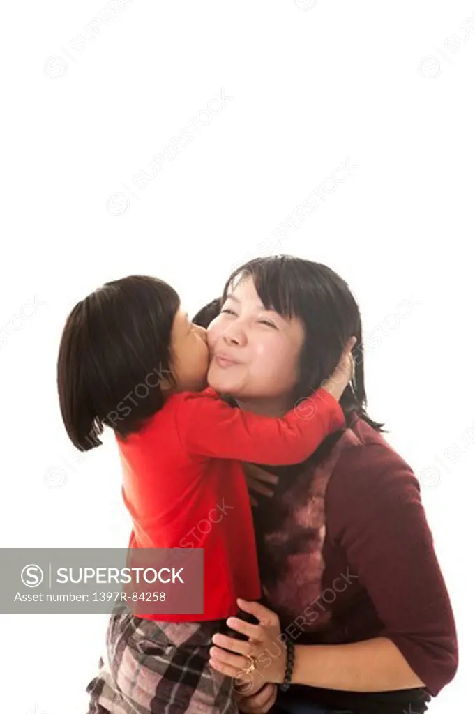 Family with one child kissing and looking away with smile