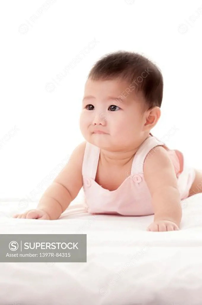 Depressed baby girl crawling on sheet