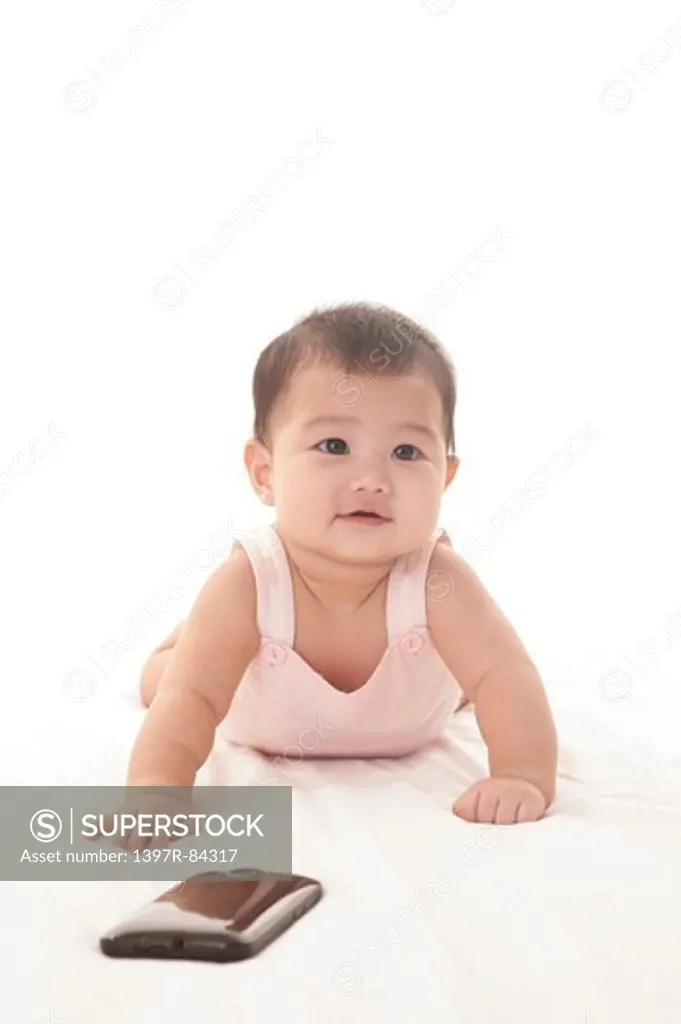 Baby girl crawling on sheet and smiling