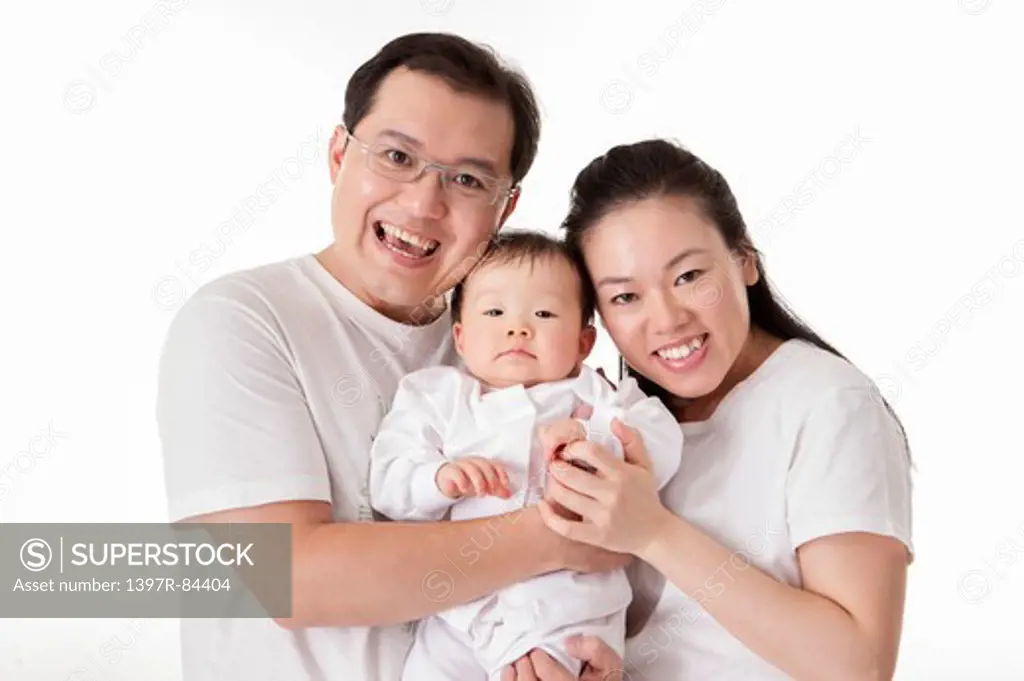 Family with one child smiling at the camera together